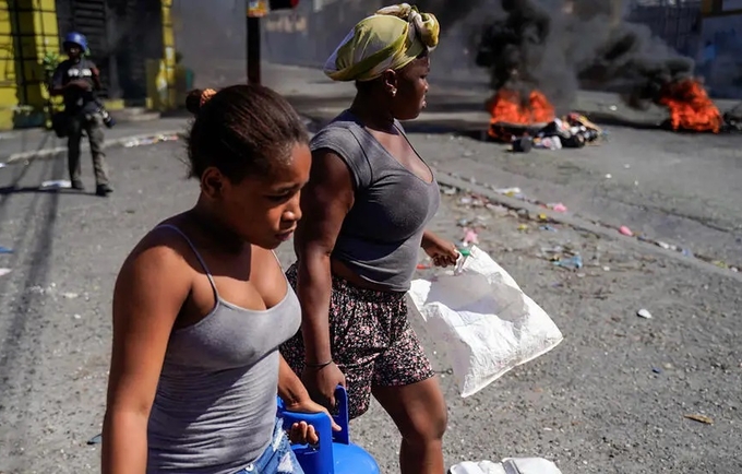 Des femmes transportent des bonbonnes de gaz propane... 3 des hôpitaux seraient fermés... © RICHARD PIERRIN/AFP via Getty Images