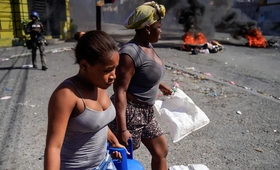 Des femmes transportent des bonbonnes de gaz propane... 3 des hôpitaux seraient fermés... © RICHARD PIERRIN/AFP via Getty Images