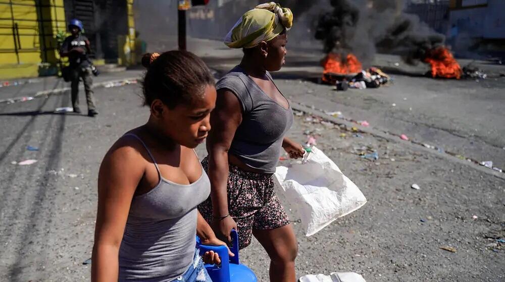 Des femmes transportent des bonbonnes de gaz propane... 3 des hôpitaux seraient fermés... © RICHARD PIERRIN/AFP via Getty Images
